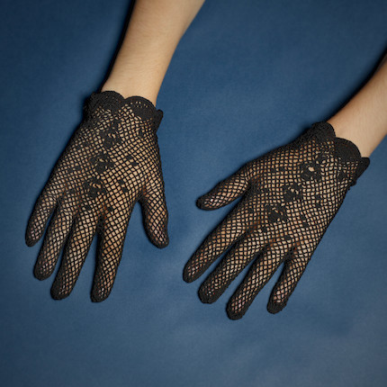 Bonhams : A PAIR OF RUTH BADER GINSBURG BLACK LACE GLOVES. Black cotton fishnet  gloves with knitted floral pattern to back of hand, scalloped wrists, 185 x  97 mm.