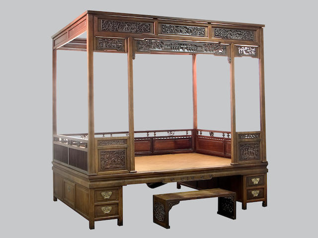 A carved mixed wood canopy bed, together with a foot stool