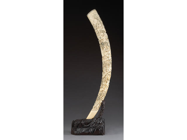 A massive carved ivory tusk