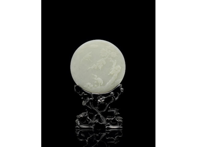 A finely carved white jade circular plaque Qianlong
