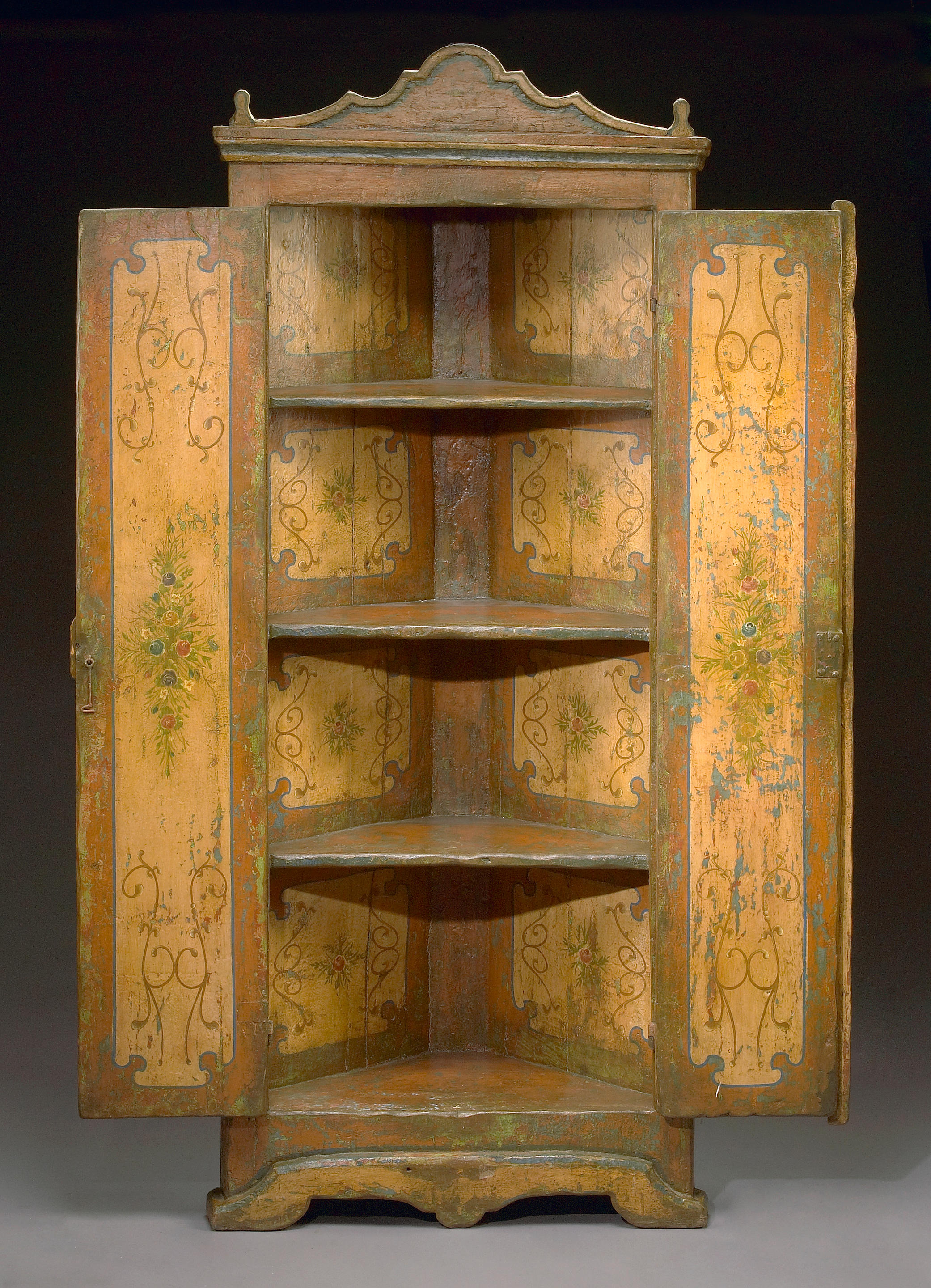 A Portuguese Baroque style paint decorated corner cupboard