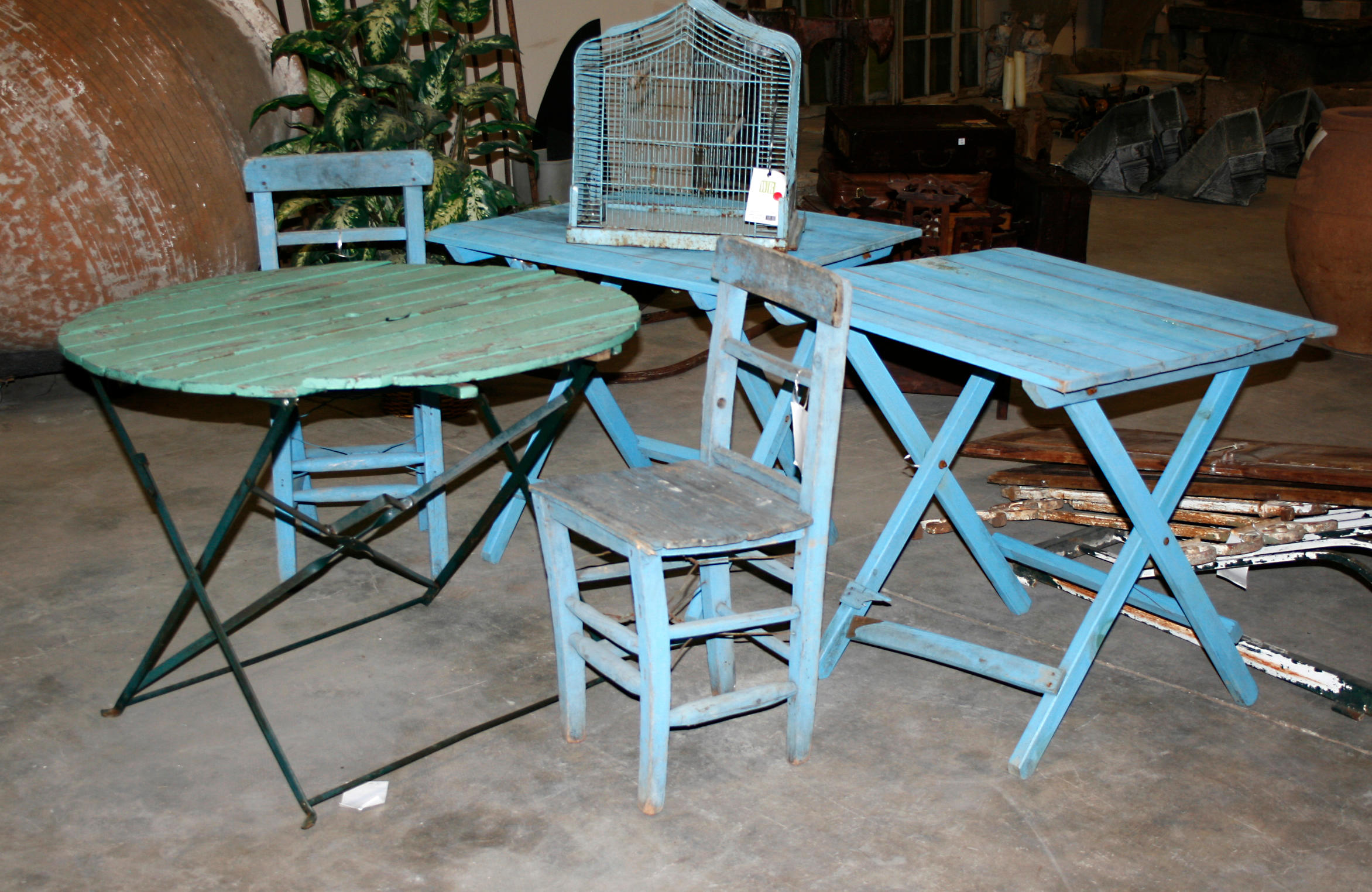 Three painted wood tables, pair of chairs and a bird cage