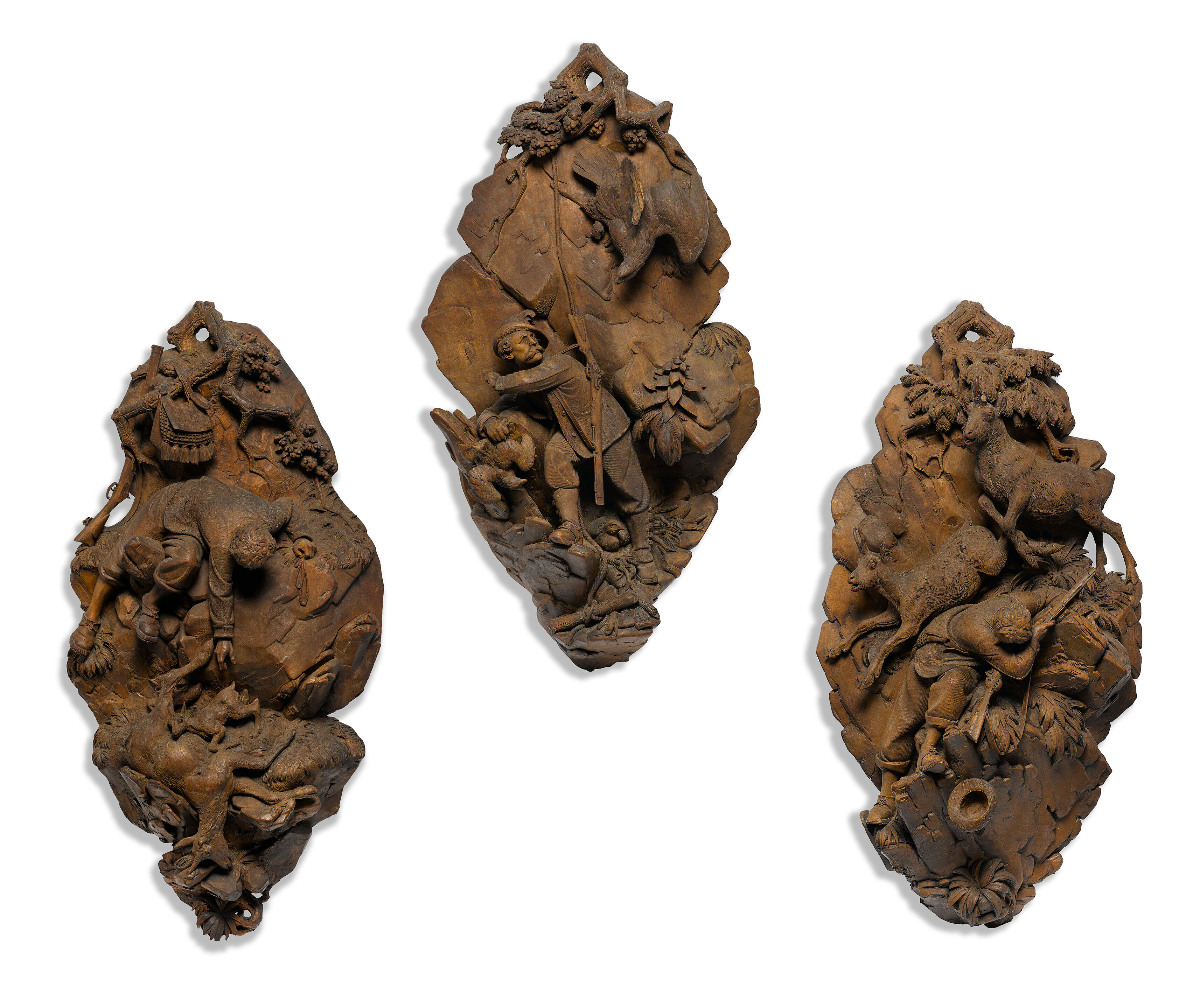 A set of three Black Forest carved lindenwood wall panels attrib