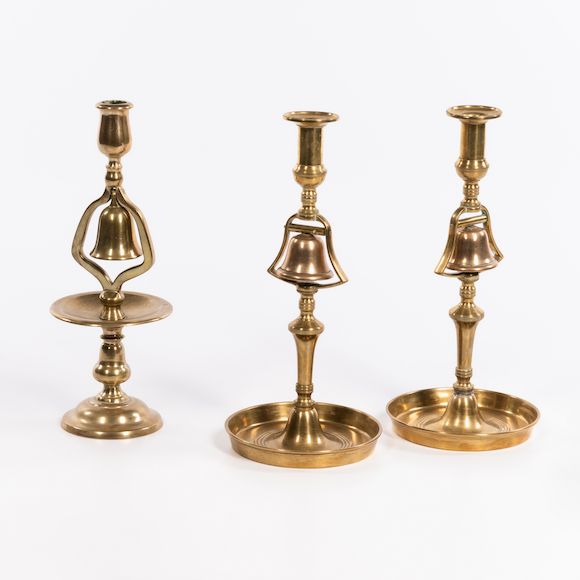 Bonhams Skinner Three Brass Bell Candlesticks, 18th/19th century.