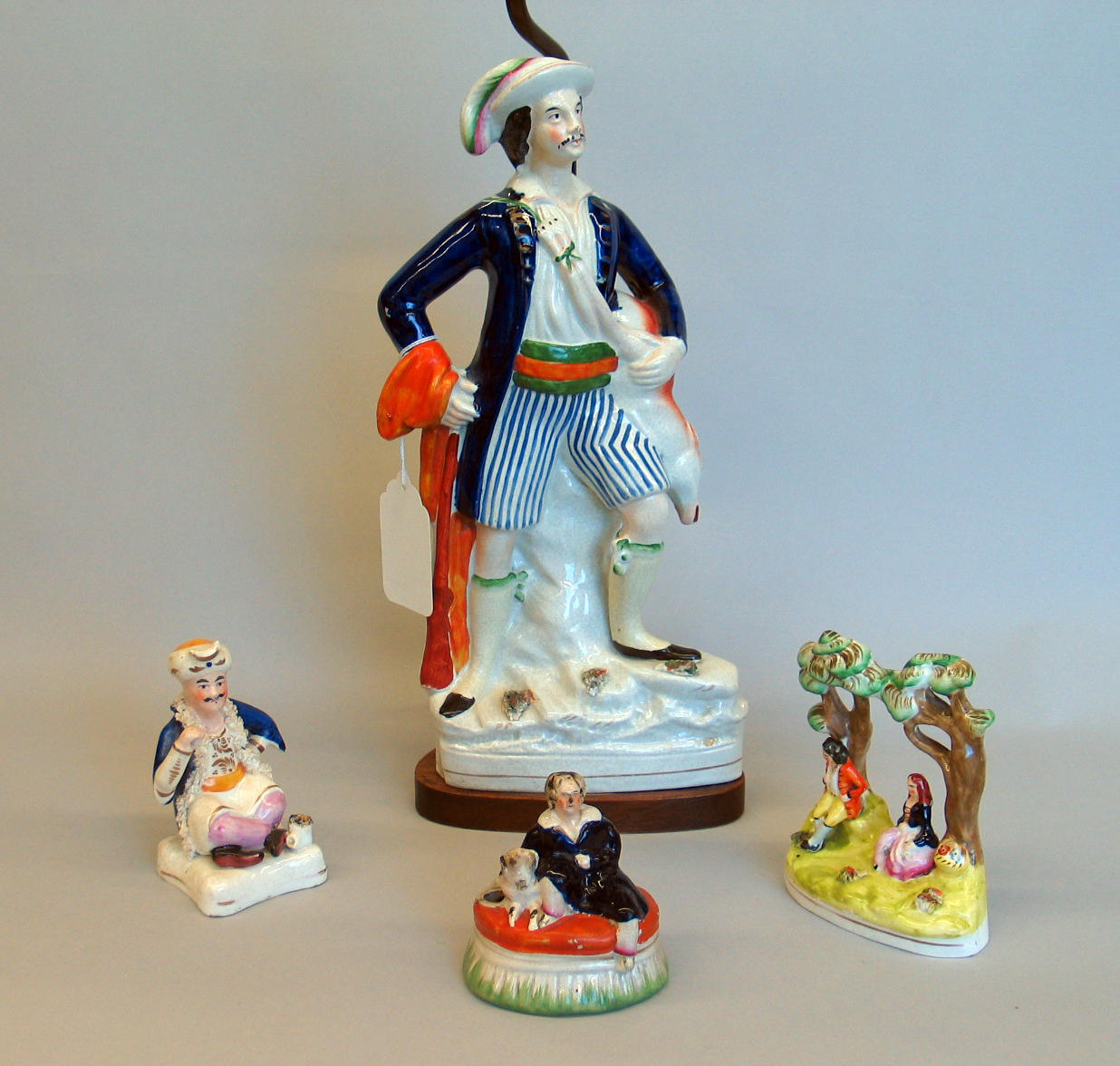 An assembled grouping of four Staffordshire pottery figures