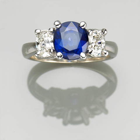 A sapphire and 18k gold diamond three stone ring