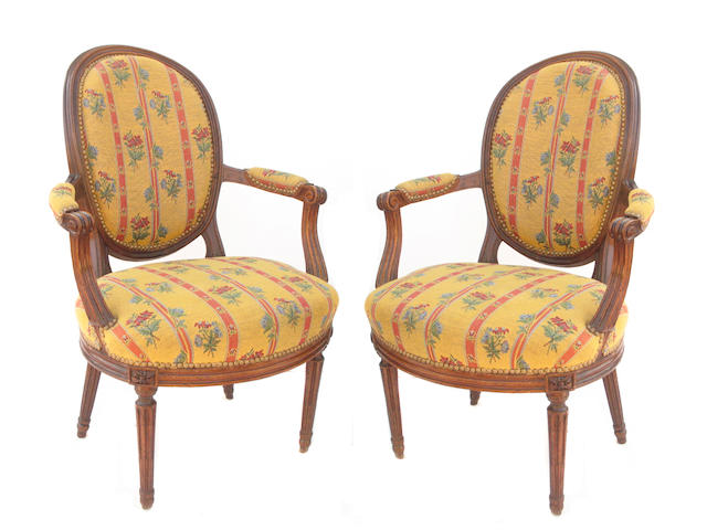 A pair of Louis XVI walnut and upholstered fauteuils