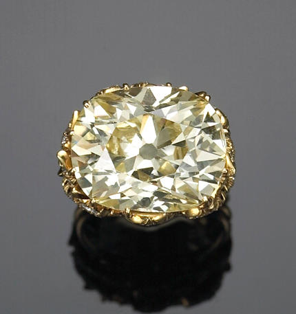 A fancy yellow diamond and eighteen karat gold solitaire ring, Julius Cohen,