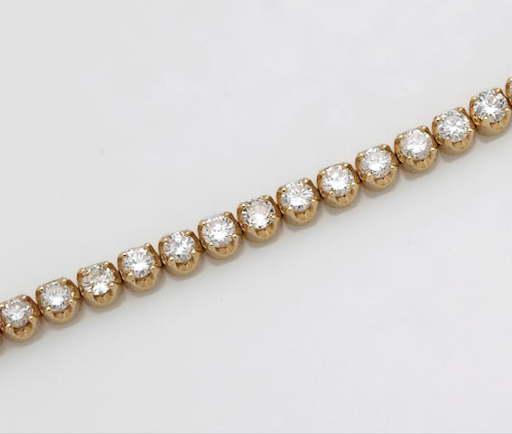 A diamond and fourteen karat gold line bracelet