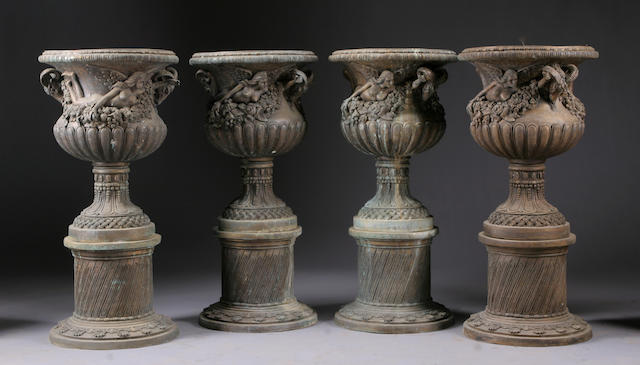 A set of four Neoclassical style patinated bronze jardini&#232;res on integral bases