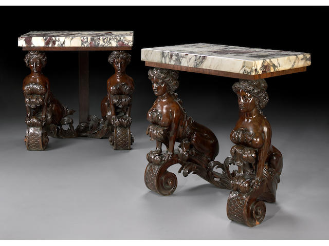 A pair of Palladian style carved walnut console tables