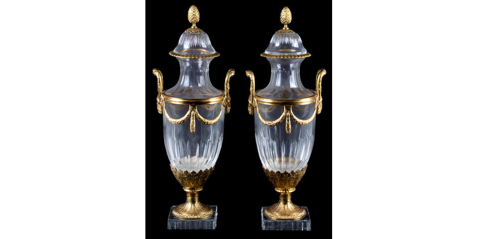 A pair of gilt bronze mounted glass covered urns