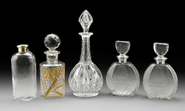 An assembled group of five decanters