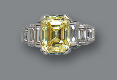 A fancy colored diamond, diamond and emerald ring