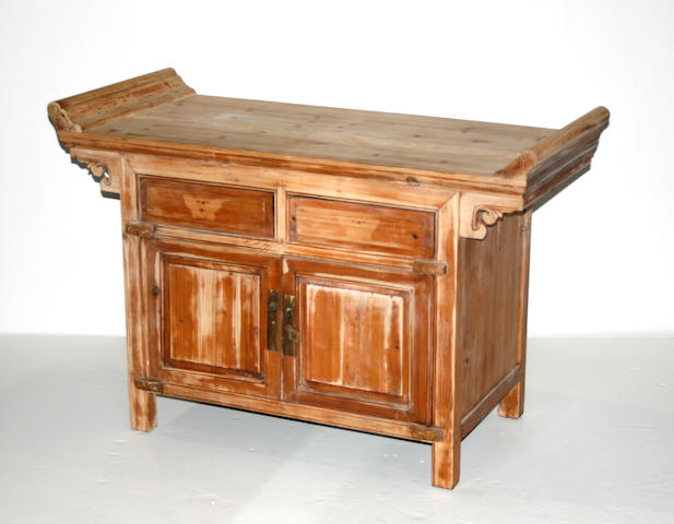 A small soft wood console cabinet with scrolled top panels