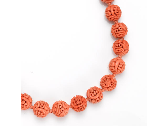 A carved coral bead and gold-plated necklace