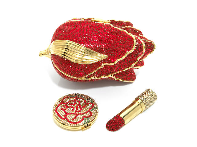 A red crystal and gold colored metal detailing tulip minaudiere together with a crystal "lipstick" lipstick container and a crystal flower compact,