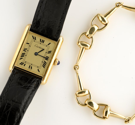 A gold-plated silver wristwatch with leather strap, Must de Cartier, together with an eighteen karat gold stirrup link bracelet image 1