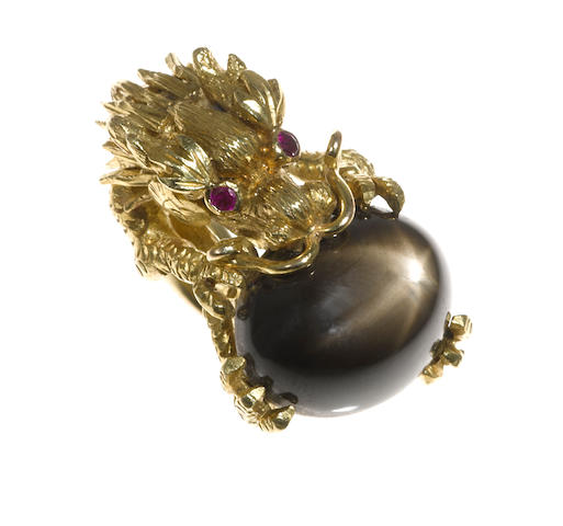 A black star sapphire, ruby and eighteen karat gold dragon motif ring