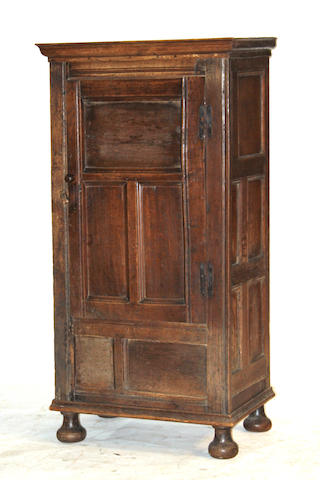 A Baroque style oak single door cupboard