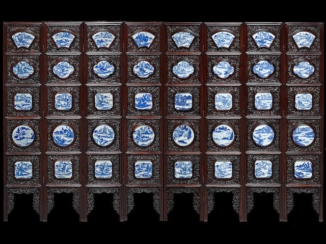 A mixed hardwood eight-panel floor screen inset with blue and white porcelain plaques Late Qing/Republic period