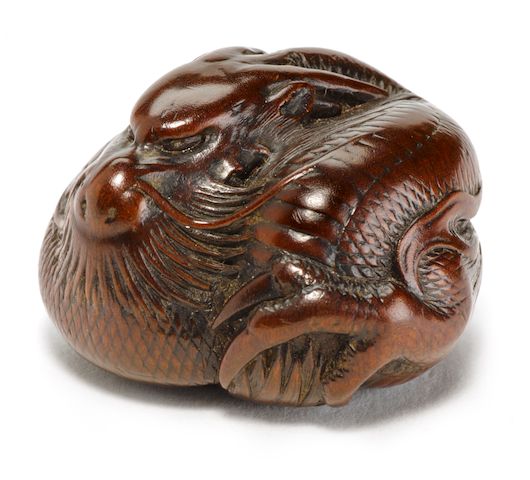 A wood netsuke of a coiled dragon By Ikkan, Nagoya, Edo period (19th century)