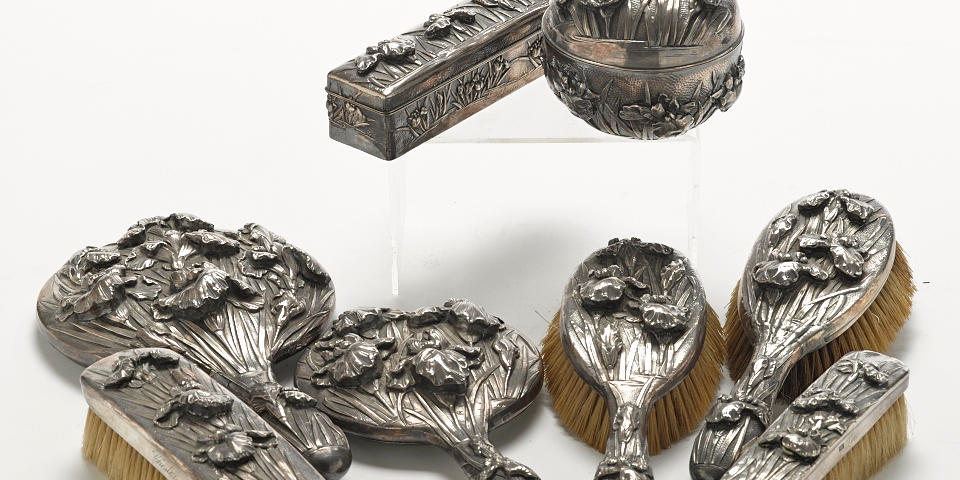 A Japanese Export silver iris-repousse-decorated eight piece vanity set with character marks, circa 1900