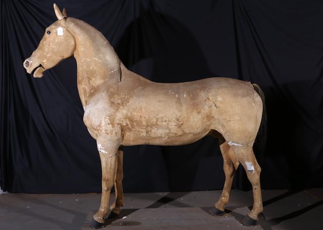 A full-size light brown plaster horse,