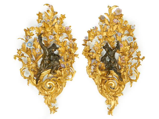 An impressive pair of Rococo style porcelain mounted gilt and patinated bronze four light bras de lumi&#232;re
