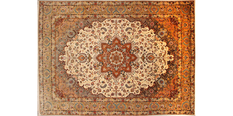 A Tabriz carpet size approximately 9ft. 10in. x 13ft. 6in.