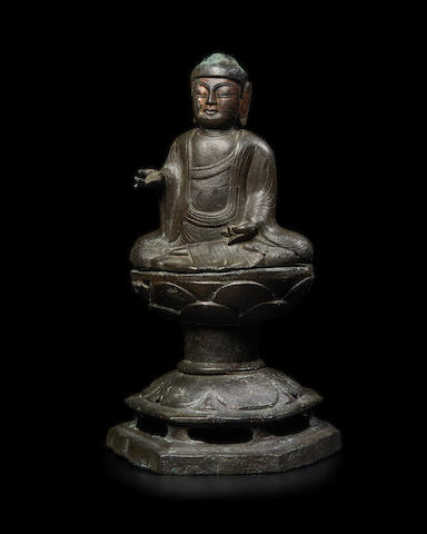 An extremely rare gilt bronze figure of a Buddha on a stand