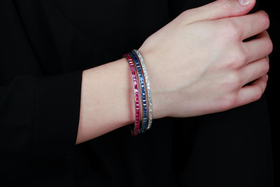 A trio of diamond, sapphire and ruby bangle bracelets