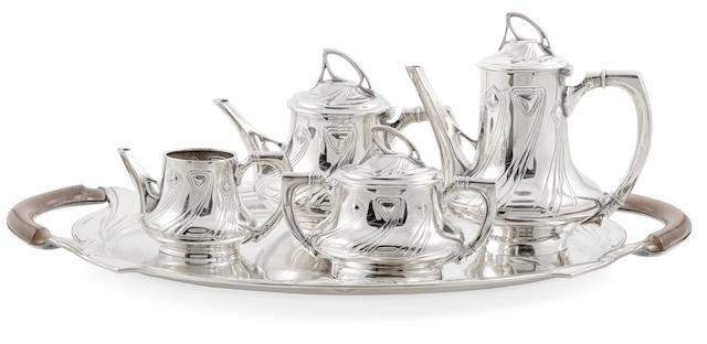 A Wurttembergische Mettalwarenfabrik (WMF) Silver Plated Metal and Mahogany Five piece Tea Set Early 20th centuryComprising a tea pot, water pot, sugar bowl with cover, creamer and tray, stamped WMF and with various hallmarks.length of tray 23&#189;in (60cm); height of tea pot 9in (23cm)