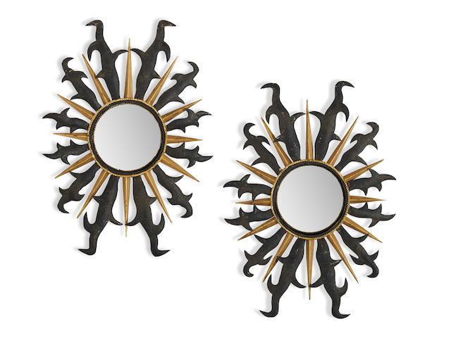 Tony Duquette (1914-1999) Pair of Sunburst Mirrorsdesign introduced 1999in the manner of Gilbert Poillerat, gilt and painted metal, hubcapsheight 32 3/4in (83.3cm); width 23in (58.5cm); depth 2 1/2 to 3 1/2in (5 to 9cm)