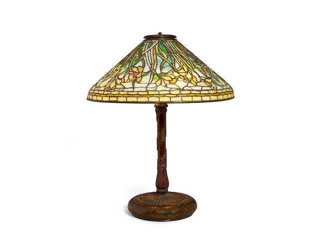 Tiffany Studios (1899-1930) Daffodil Table Lampcirca 1905leaded glass, patinated bronze, shade with bronze tag stamped 'TIFFANY STUDIOS NEW YORK', base stamped '28619 TIFFANY STUDIOS NEW YORK' with maker's monogramheight 25 1/2in (64.7cm); diameter of shade 20 1/4in (51.4cm)