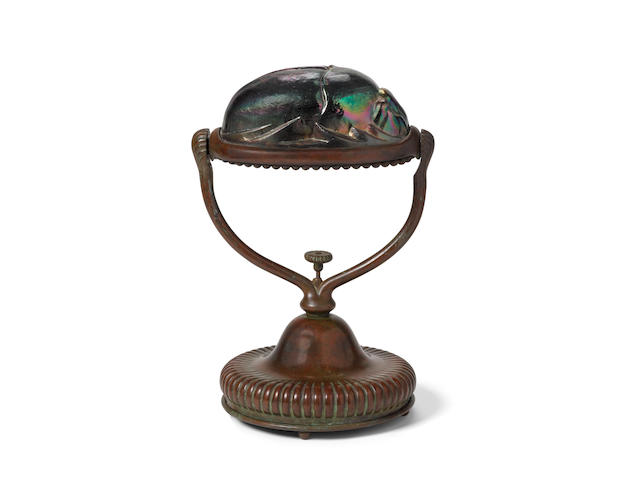 Tiffany Studios (1899-1930) Scarab Desk Lampcirca 1910patinated bronze, Favrile glass, stamped 'TIFFANY STUDIOS NEW YORK S 1427' with Tiffany Glass Decorating Co. monogram on the undersideheight 9in (23cm); diameter 5in (13cm)