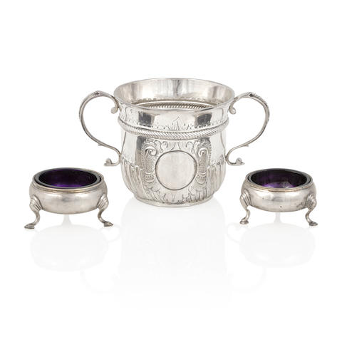 A QUEEN ANNE SILVER CUP AND TWO GEORGE II SALT CELLARS by various makers, London, first half 18th century