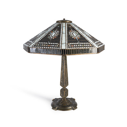 Tiffany Studios Empire Jewel Table Lamp, New York, New York, 1910-1913, leaded glass and patinated bronze, shade with stamped mark Tiffany Stvdios N.Y. 1958, dia. 23 1/4, with an Old English base, four-socket cluster, Perkins paddle switches, stamped mark Tiffany Studios New York 557, total ht. 25 3/4 in.Literature Alistair Duncan, Tiffany Lamps and Metalwork, (new edition), shade, plate 833, p. 214, base, plate 834, p. 215. image 1